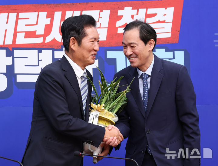 [서울=뉴시스] 김금보 기자 = 우상호(오른쪽) 정무수석이 4일 오후 서울 여의도 국회에서 정청래 더불어민주당 당대표에게 대통령이 보낸 당대표 취임 축하난을 전달하고 있다. 2025.08.04. kgb@newsis.com