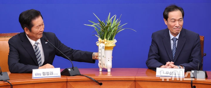 [서울=뉴시스] 김금보 기자 = 정청래(왼쪽) 더불어민주당 당대표가 4일 오후 서울 여의도 국회에서 열린 우상호 정무수석과의 면담에서 대통령에게 받은 당대표 취임 축하난을 살펴보고 있다. 2025.08.04. kgb@newsis.com