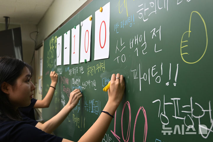 [수원=뉴시스] 김종택 기자 = 2026학년도 대학수학능력시험 100일을 하루 앞둔 4일 경기 수원시 영통구 태장고등학교에서 고3 수험생들이 칠판에 수능 응원 메시지를 쓰고 있다. 2025.08.04. jtk@newsis.com