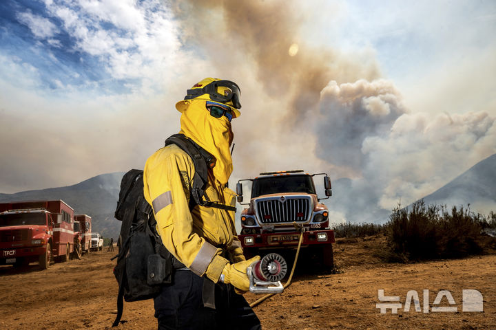 [로스파드리스국유림=AP/뉴시스] 4일(현지 시간) 미 캘리포니아주 로스파드리스 국유림에서 한 소방관이 '기퍼드 파이어' 산불을 진화하기 위해 연장에 진입하고 있다. 2025.08.05.