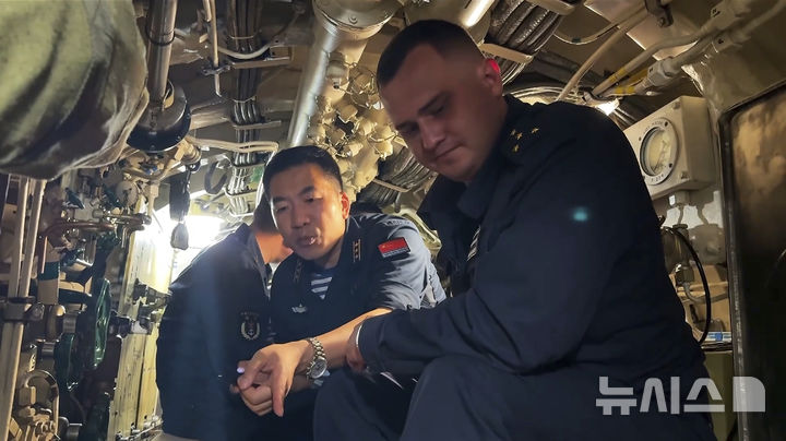 [블라디보스토크=AP/뉴시스] 중국과 러시아 해군이 5일 러시아 블라디보스토크 인근 해상 및 공역에서 진행된 연례 합동훈련을 마무리한 뒤, 합동 해상순찰에 돌입했다. 사진은 러시아 국방부가 발표한 영상에서 캡쳐한 사진으로, 양국 군인이 함께 훈련 중인 모습. 2025.08.06&nbsp; 