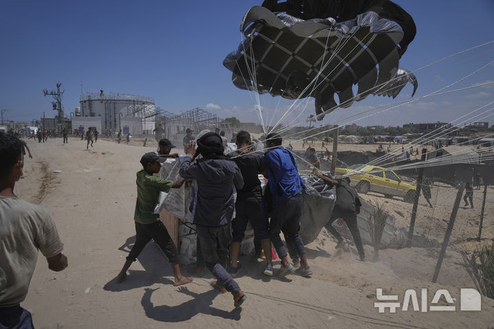 [데이르알발라=AP/뉴시스] 5일(현지 시간) 가자지구 중부 데이르알발라에서 팔레스타인 주민들이 낙하산으로 투하된 인도적 지원 물품에 몰려들고 있다. 2025.08.06.