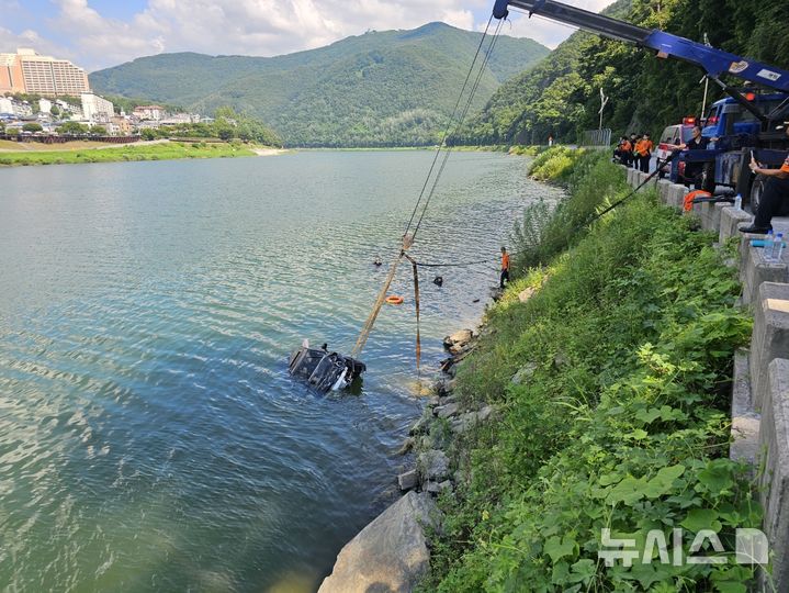 [청주=뉴시스] 5일 낮 12시54분께 충북 단양군 단양읍 심곡리의 한 도로에서 A(60대)씨가 몰던 승용차가 인근 하천으로 추락했다. 소방당국은 인명구조 이후 차량 인양작업을 벌이고 있다. (사진=충북소방본부 제공) 2025.08.05. photo@newsis.com