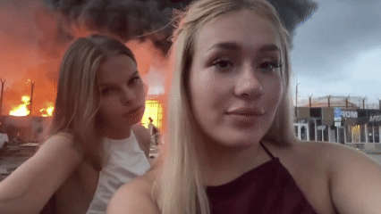 [뉴시스] 우크라이나의 드론 공격으로 화재가 발생한 석유 저장소를 배경으로 동영상을 촬영해 소셜미디어에 게시한 러시아 청년들이 경찰에 체포됐다. (사진=@sentdefender 엑스 갈무리) 2025.08.05 *재판매 및 DB 금지