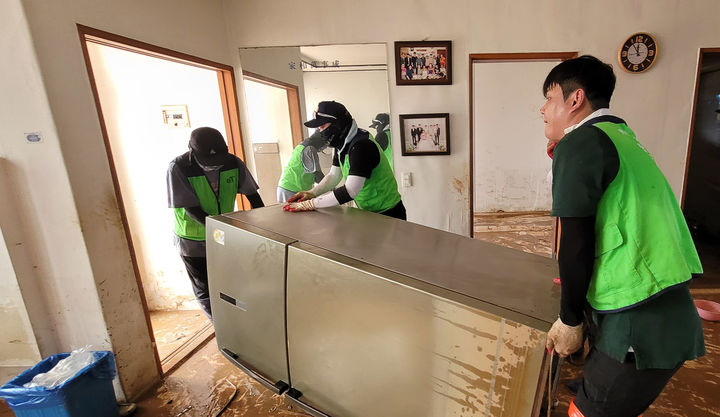 [세종=뉴시스]한국농수산식품유통공사(aT)가 5일 집중호우로 큰 피해를 입은 전남 무안군 침수 피해 농가를 찾아 일손 돕기를 실시하는 모습. (사진=aT 제공) *재판매 및 DB 금지