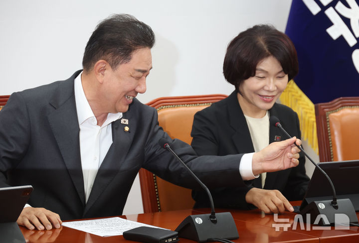 [서울=뉴시스] 조성봉 기자 = 김병기 더불어민주당 원내대표가 5일 오전 서울 여의도 국회에서 열린 원내대책회의에서 한정애 정책위의장의 마이크 위치를 조정해주고 있다. 2025.08.05. suncho21@newsis.com