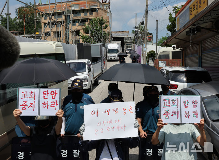 [서울=뉴시스] 배훈식 기자 = 경찰이 서부지법 폭력 난동 사태와 관련해 전광훈 목사에 대한 압수수색에 들어간 5일 오전 서울 성북구 사랑제일교회 앞에서 신도들이 항의 피켓을 들고 있다. 2025.08.05. dahora83@newsis.com