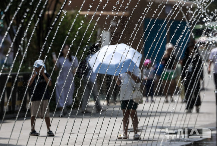 [서울=뉴시스] 정병혁 기자 = 더운 날씨가 이어지고 있는 5일 서울 종로구 광화문광장에서 한 시민이 양산을 들고 이동하고 있다. 2025.08.05. jhope@newsis.com