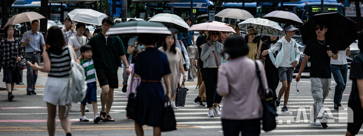 [서울=뉴시스] 정병혁 기자 = 더운 날씨가 이어지고 있는 지난 5일 서울 종로구 광화문네거리에서 양산을 쓴 시민들이 이동하고 있다. 2025.08.05. jhope@newsis.com