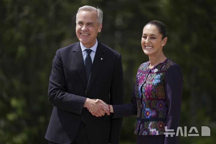 [캐내내스키스=AP/뉴시스] 사진은 마크 카니 캐나다 총리(왼쪽)와 클라우디아 셰인바움 멕시코 대통령이 지난 6월 17일 캐나다 앨버타주 캐내내스키스에서 열린 주요 7개국(G7) 정상회의에서 악수하는 모습. 2025.08.06.