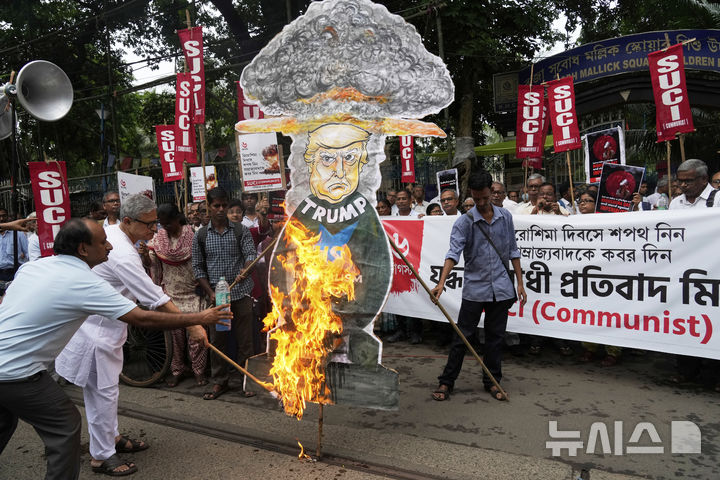 [콜카다=AP/뉴시스]인도 공산당인 사회주의 통합센터의 한 지도자가 6일(현지시각) 미국의 제국주의에 항의하는 시위에서 도널드 트럼프 미 대통령 모형에 불을 붙이고 있다. 2025.8.7.
