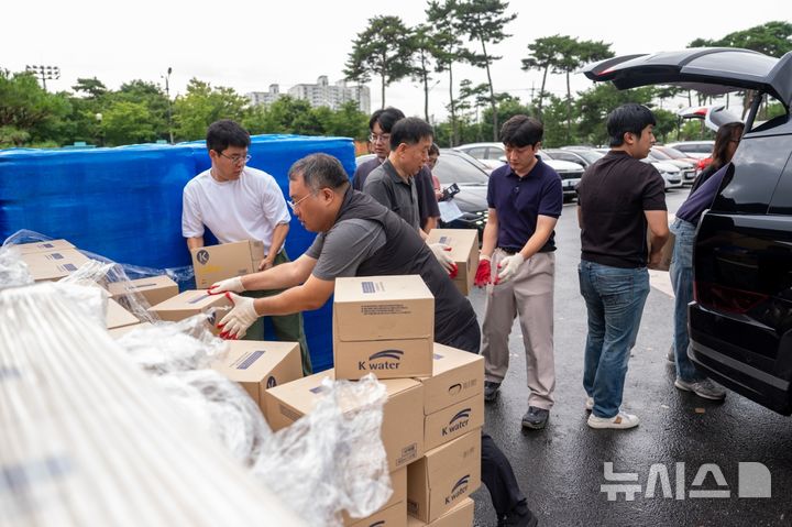 [증평=뉴시스] 충북 증평군청 직원들이 6일 군 스포츠센터 앞에서 마을별로 배부할 생수를 옮기고 있다. 전날 증평군에서는 송수관로 누수로 단수 피해가 발생했다. 수자원공사 등 관계당국은 이틀째 복구 작업을 벌이고 있다. (사진=증평군 제공) 2025.08.06. photo@newsis.com