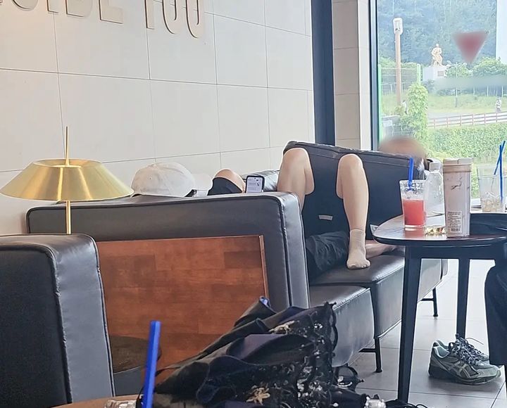 [뉴시스] 카페 소파에 드러누워 휴대전화를 보는 남녀. (출처=보배드림) *재판매 및 DB 금지