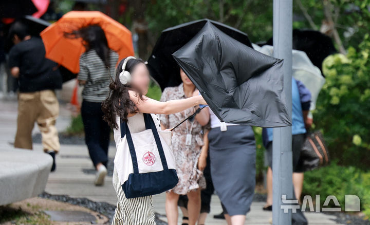 [서울=뉴시스] 이영환 기자 = 돌풍을 동반한 비가 내린 6일 오후 서울 종로구 광화문 인근 거리에서 한 시민의 우산이 바람에 뒤집히고 있다. 2025.08.06. 20hwan@newsis.com