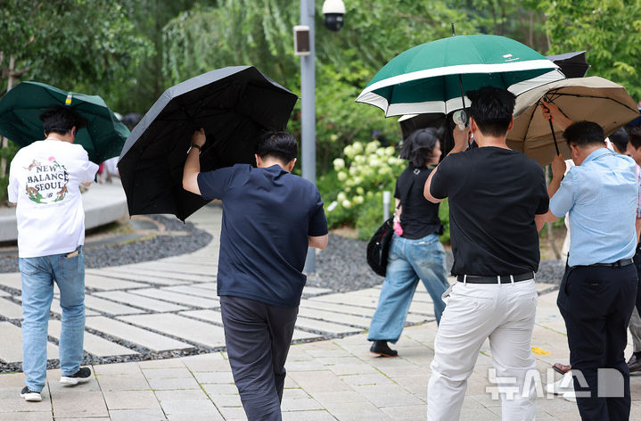 [서울=뉴시스] 이영환 기자 = 돌풍을 동반한 비가 내린 6일 오후 서울 종로구 광화문 인근 거리에서 시민들이 우산을 붙잡은채 걸어가고 있다. 2025.08.06. 20hwan@newsis.com