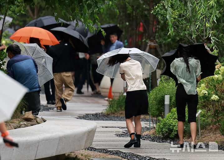 [서울=뉴시스] 이영환 기자 = 돌풍을 동반한 비가 내린 6일 오후 서울 종로구 광화문 인근 거리에서 시민들이 우산을 붙잡은채 걸어가고 있다. 2025.08.06. 20hwan@newsis.com