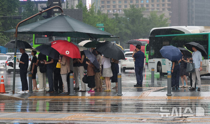 [서울=뉴시스] 권창회 기자 = 수도권을 비롯한 중부지역에 호우가 예보된 6일 서울 종로구 광화문광장에서 시민들이 햇빛그늘막 아래서 신호를 기다리고 있다. 2025.08.06. kch0523@newsis.com
