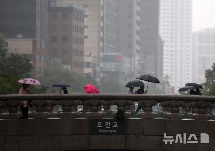 [서울=뉴시스] 배훈식 기자 = 전국에 많은 비가 내린 지난달 6일 오후 서울 종로구 청계천 모전교 를 우산 쓴 시민들이 건너고 있다. 2025.08.06. dahora83@newsis.com