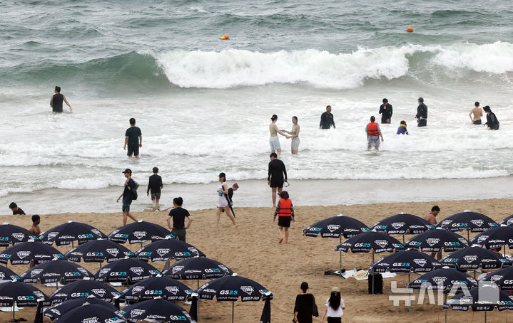 [부산=뉴시스] 하경민 기자 = 비가 내린 6일 부산 해운대구 해운대해수욕장을 찾은 피서객들이 물놀이를 즐기고 있다. 2025.08.06. yulnetphoto@newsis.com