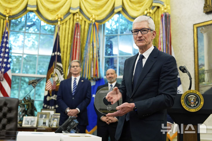 [워싱턴=AP/뉴시스] 6일(현지 시간) 미 워싱턴 DC 백악관 오벌 오피스에서 팀 쿡 애플 CEO가 도널드 트럼프 대통령에게 전달할 선물을 들어보이고 있다. 애플은 이날 국내 사업에 4년간 총 6000억 달러(831조3000억원)를 투자한다고 밝혔다. 2025.08.07.