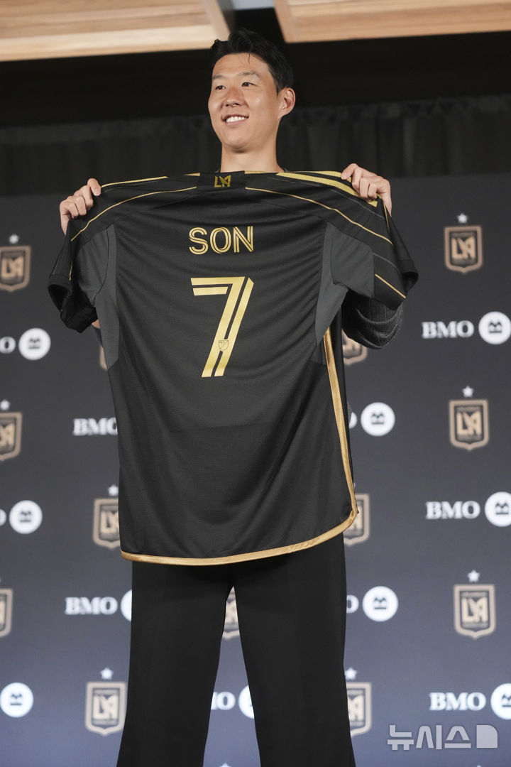 [로스앤젤레스=AP/뉴시스] 손흥민이 6일(현지 시간) 미 캘리포니아주 로스앤젤레스(LA)의 BMO 스타디움에서 열린 미국프로축구(MLS) LA FC 입단 기자회견에서 본인의 등번호 7번이 새겨진 유니폼을 들고 포즈를 취하고 있다. 2025.08.07.