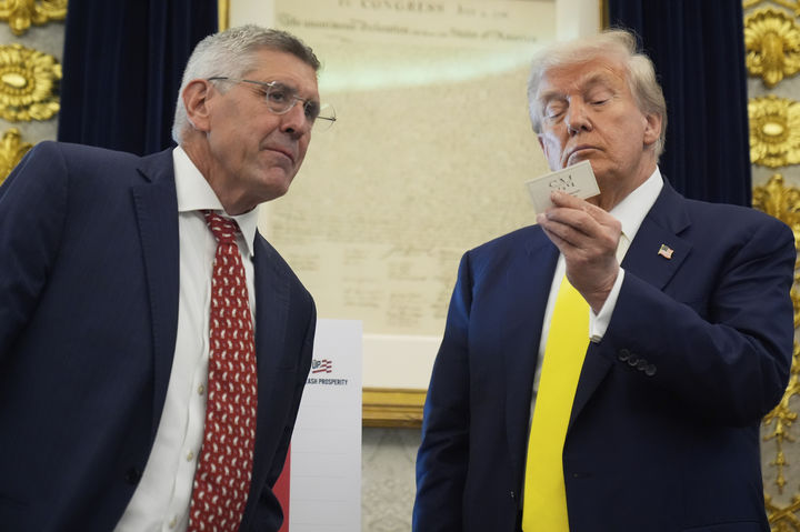 [워싱턴=AP/뉴시스] 도널드 트럼프 미국 대통령이 7일(현지 시간) 백악관 오벌 오피스에서 보수 성향 싱크탱크인 헤리티지 재단의 수석 방문 연구원 스티븐 무어가 건넨 명함을 보고 있다. 2025.08.08.