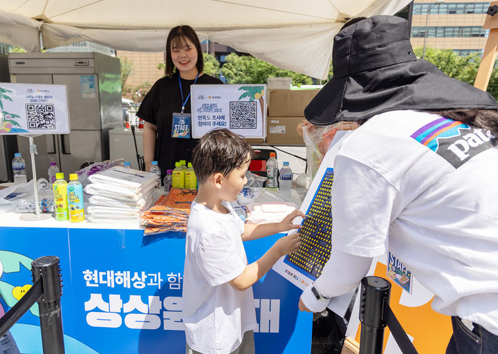 [서울=뉴시스] 한 어린이가 현대해상의 광화문광장 '상상원정대' 스탬프 챌린지에 참여하고 있다. (사진=현대해상 제공) 2025.08.08. photo@newsis.com *재판매 및 DB 금지