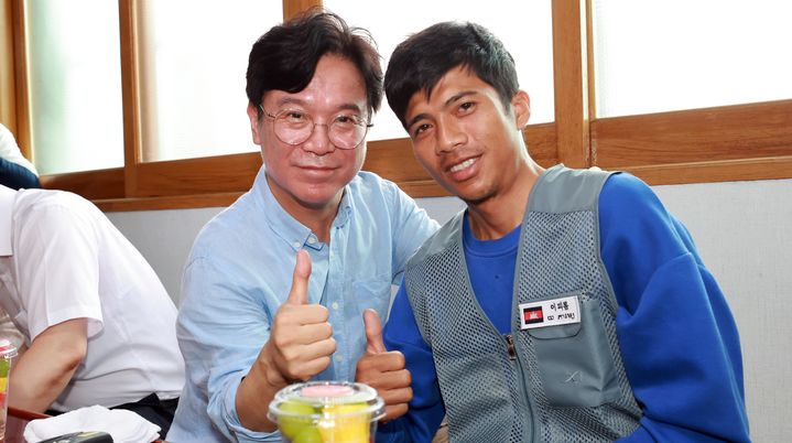 [서울=뉴시스] 김영훈 고용노동부 장관이 지난 8월 8일 전북 완주군의 외국인 고용 농가를 방문해 간담회에 앞서 외국인 노동자에게 한글 이름표를 붙여준 뒤 기념촬영 하고 있다. (사진=고용노동부 제공) 2025.08.08. photo@newsis.com *재판매 및 DB 금지