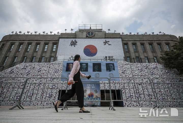 [서울=뉴시스] 정병혁 기자 = 8일 서울 중구 서울광장에 조성된 태극기 언덕 앞에서 시민들이 이동하고 있다. 2025.08.08. jhope@newsis.com