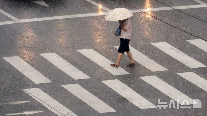 [서울=뉴시스] 홍효식 기자 = 소나기가 내린 8일 서울 중구 을지로1가 사거리에서 한 시민이 우산을 쓰고 발걸음을 재촉하고 있다. 2025.08.08. yesphoto@newsis.com