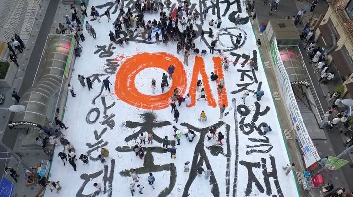 [대전=뉴시스]대전 0시 축제의 성공을 기원하는 대형 붓글씨 퍼포먼스가 8일 성심당 앞에서 열렸다. '0시축제' 문구가 선명하게 적혀있다. (사진=대전사회혁신센터 제공) 2025. 08. 09 photo@newsis.com *재판매 및 DB 금지