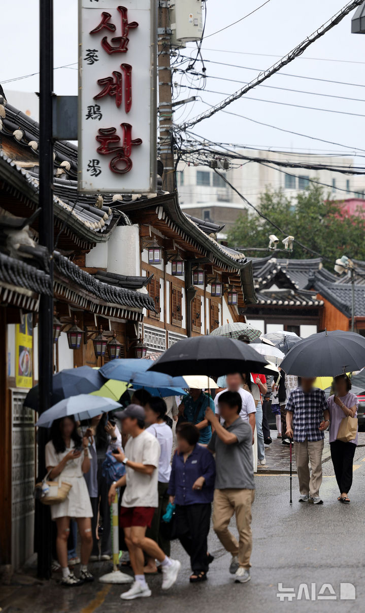 [서울=뉴시스] 홍효식 기자 = 말복인 9일 서울 종로구 한 삼계탕 전문점을 찾은 사람들이 우산을 쓰고 입장을 기다리고 있다. 2025.08.09. yesphoto@newsis.com