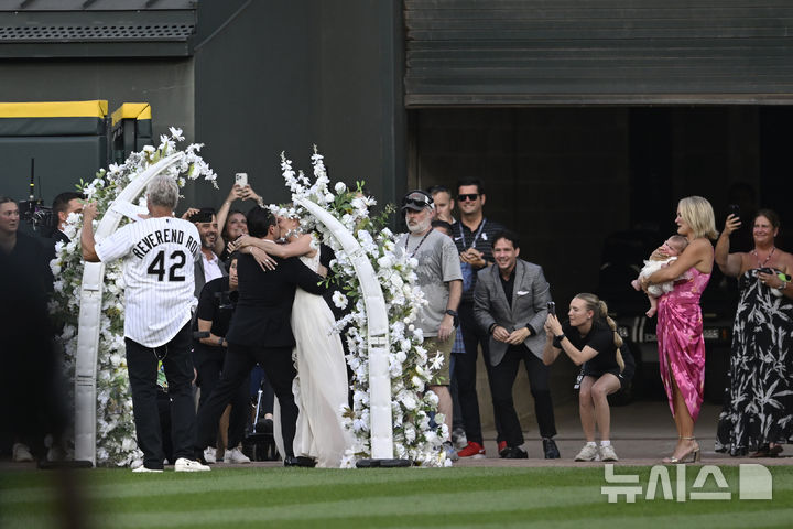 [시카고=AP/뉴시스] 시카고 화이트삭스와 클리블랜드 가디언즈의 야구 경기 중 열린 60초간의 결혼식에서 두 명의 화이트삭스 팬이 결혼 서약서를 주고받은 후 키스하고 있다. 2025.08.09