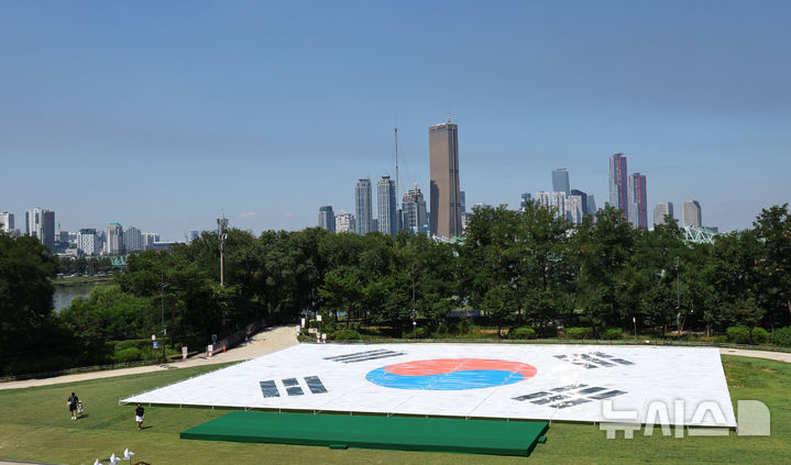 [서울=뉴시스] 최진석 기자 = 광복 80주년을 앞둔 10일 서울 노들섬 잔디마당에 대형 태극기가 전시되어 있다. 노들 야외스퀘어에서는 현존하는 가장 오래된 ‘데니 태극기’부터 일제강점기, 광복 이후의 태극기까지 시대별 변화를 보여주는 16점의 대형 태극기가 한반도 형상 위에 전시된다. 2025.08.10. myjs@newsis.com