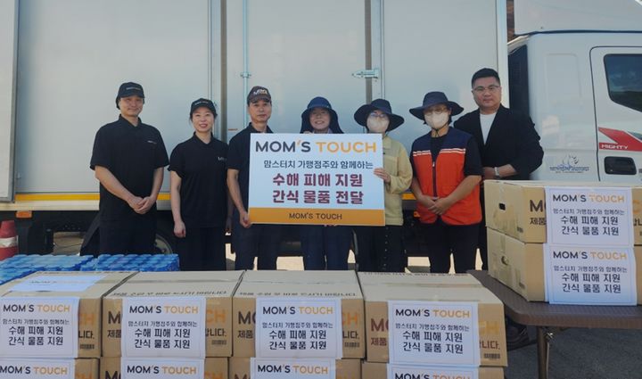 [서울=뉴시스] 지난 8일 경남 산청군 신안면에 위치한 집중호우 피해 현장에서 맘스터치 본사 임직원 및 가맹점주들이 간식 물품을 전달하고 수해복구 현장 관계자들과 기념촬영을 진행하고 있다. (왼쪽부터) 김성훈·곽은주 맘스터치 함양점 점주, 이종민 경상대점 점주, 박혜나 경상남도 자원봉사센터 부장, 반영경 경상남도 산청군청 복지정책과 계장, 자원봉사자, 강한성 맘스터치 전략지원부문장.(사진=맘스터치앤컴퍼니 제공) *재판매 및 DB 금지