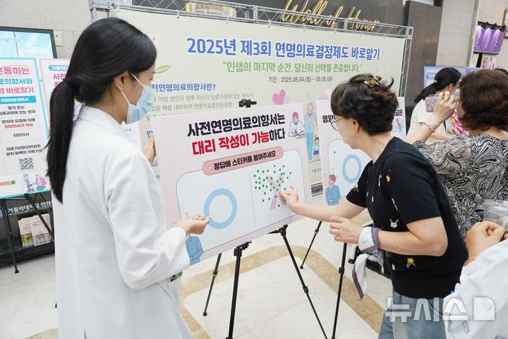 [인천=뉴시스] 연명의료결정제도 바로알기 캠페인에 참여한 내원객이 OX 퀴즈 이벤트에 참여하고 있다. (사진=인천성모병원 제공) 2025.08.11. photo@newsis.com