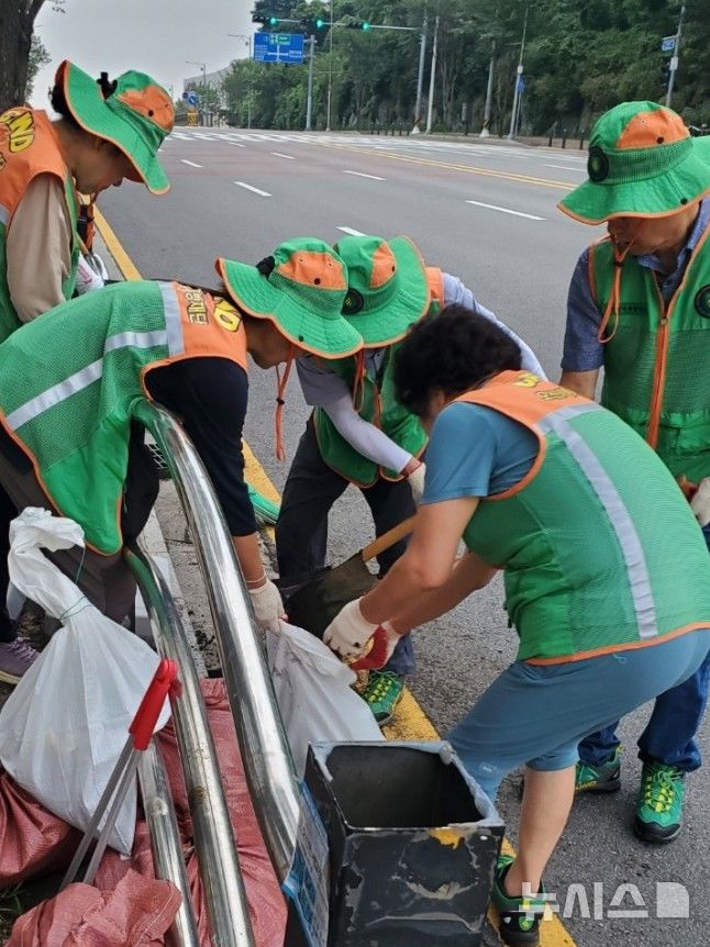 [오산=뉴시스] 경기 오산시 지역자율방재단이 도로변 배수로와 빗물받이를 정비 작업 모습. (사진=오산시 제공) 2025.08.11. photo@newsis.com 