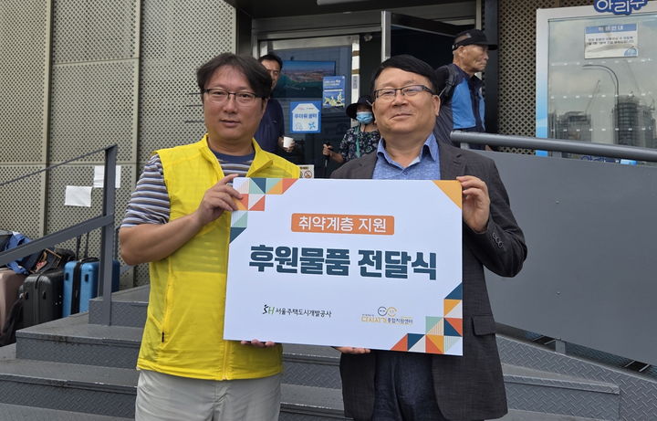 [서울=뉴시스] 민동조 SH 자산운용본부장(오른쪽)과 우대경 다시서기센터 팀장이 폭염 대비 물품 전달 후 기념 촬영을 하고 있다. 2025.08.11. (사진=SH 제공) *재판매 및 DB 금지