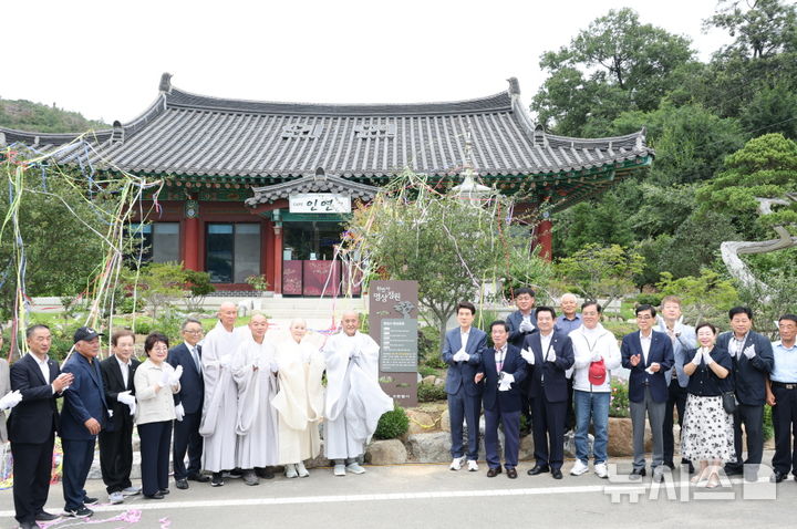 [포항=뉴시스] 송종욱 기자 = 경북 포항시 북구 신광면 원법사 명상정원이 전국 사찰 최초 민간 정원으로 공식 등록돼 11일 기념 제막식을 열었다. 사진은 제막식에서 이강덕 시장, 이재진 시의회 부의장, 해운 주지 스님, 신도들이 기념 촬영하는 모습. (사진=포항시 제공) 2025.08.11. photo@newsis.com
