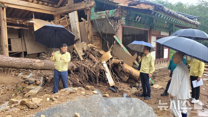[산청=뉴시스]경남도 박명균(맨 왼쪽) 행정부지사가 11일 산청군 신등면 율곡사를 찾아 집중호우 당시 파손된 대웅전 배면 벽체 현장을 살펴보고 있다.(사진=경남도 제공) 2025.08.11. photo@newsis.com