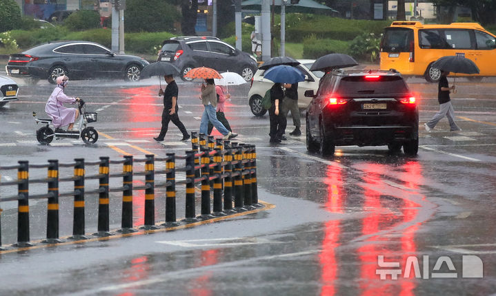 [제주=뉴시스] 우장호 기자 = 정체전선 영향으로 호우특보가 내려진 11일 오전 제주시 노형오거리 인근 거리에 우산을 쓴 시민들이 걸어가고 있다. 2025.08.11. woo1223@newsis.com