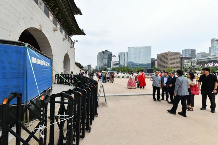 [서울=뉴시스] 허민 국가유산청장이 11일 낙서로 훼손된 서울 종로구 경복궁 광화문 석축을 찾아 피해 규모를 확인한 뒤, 긴급 복구 작업을 위해 가림막이 설치된 현장을 관계자들과 점검하고 있다. (사진=국가유산청 제공) 2025.08.11. photo@newsis.com *재판매 및 DB 금지
