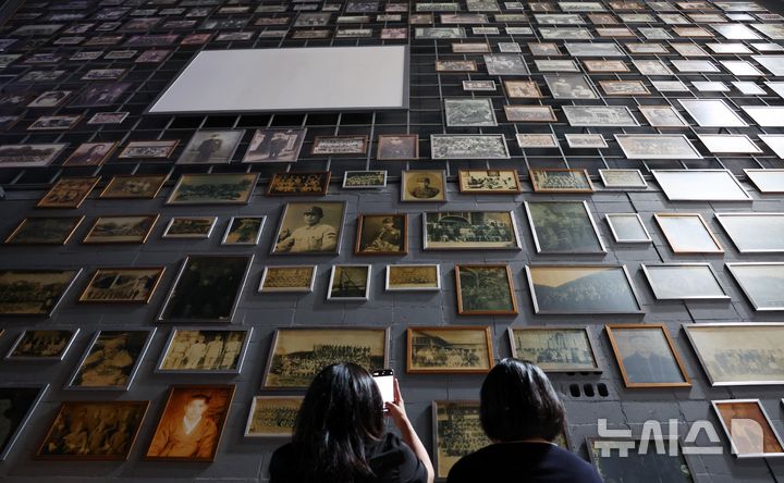 [부산=뉴시스] 하경민 기자 = 제80주년 광복절을 앞두고 지난 8월 11일 부산 남구 국립일제강제동원역사관에서 관람객들이 강제징용 피해자와 유족 등이 기증한 다양한 사진을 채운 벽면을 둘러보고 있다. 2025.12.11. yulnetphoto@newsis.com