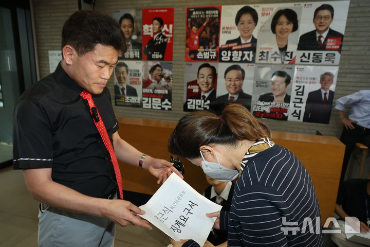 [서울=뉴시스] 고승민 기자 = 대구·경북 전당대회 합동연설회에서 '배신자' 야유를 주도한 전한길  전 한국사 강사가 11일 서울 여의도 국민의힘 당사 로비에서 '김근식 최고위원 후보 징계요구서'를 당 윤리위 관계자에게 제출하고 있다.  2025.08.11. kkssmm99@newsis.com