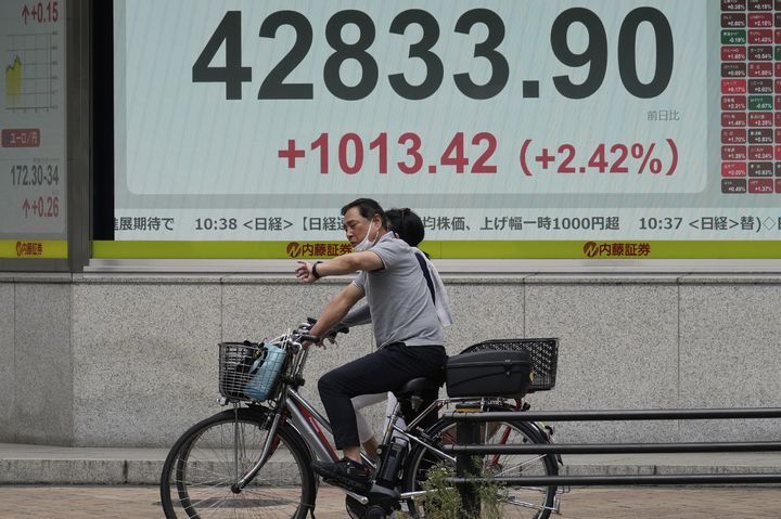 [도쿄=AP/뉴시스] 지난 8월 12일 일본 도쿄의 한 증권사의 전광판 앞을 자전거를 탄 시민이 지나가고 있다. 8일 일본 도쿄증시에서 닛케이225지수(닛케이지수)가 하락세로 출발했다. 2025.10.08.