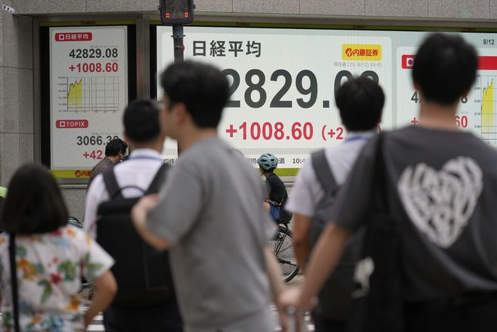 [도쿄=AP/뉴시스] 니혼게이자이신문에 따르면 닛케이225지수(닛케이평균주가)는 전 거래일보다 0.27% 오른 4만9316엔06전에 장을 마감하며 이틀 연속 사상 최고치를 경신했다. 사진은 일본 도쿄의 한 증권사의 전광판 앞에 시민들이 서 있는 모습. 2025.10.21.