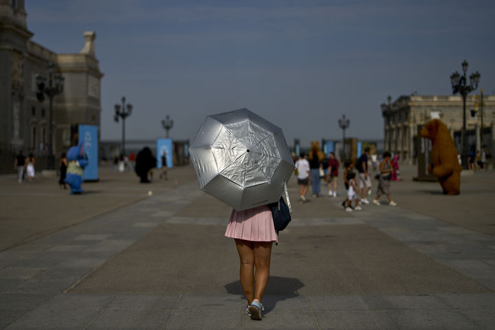 [마드리드=AP/뉴시스] 12일(현지 시간) 스페인 마드리드에서 한 여성이 양산을 쓴 채 이동하고 있다. 2025.08.13.