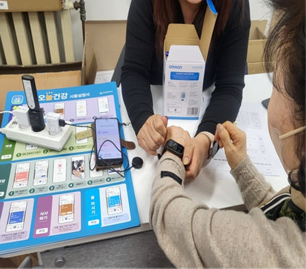 [안산=뉴시스]단원구보건소 관계자가 인공지능·사물인터넷 활용 비대면 건강관리에 참여하는 어르신에게 전자기기 착용법을 안내하고 있다.(사진=안산시 제공)2025.08.12..photo@newsis.com *재판매 및 DB 금지