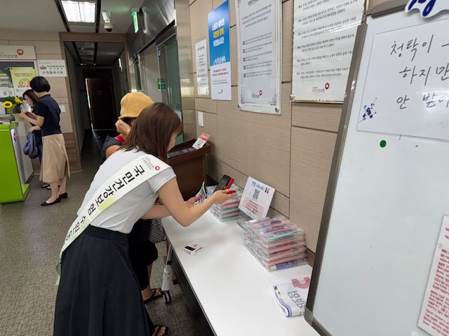 [수원=뉴시스] 건강보험공단 수원동부지사 직원이 고객에게 청렴인식도 설문조사 방법을 안내하고 있다. (사진=건보공단 수원동부지사 제공) 2025.08.12. photo@newsis.com *재판매 및 DB 금지