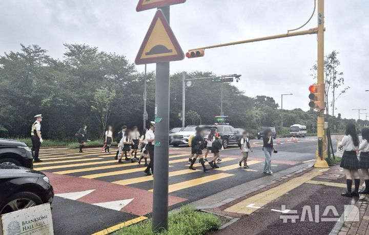 [제주=뉴시스] 제주자치경찰단 서귀포지역경찰대가 12일 오전 서귀포시 대정읍 소재 제주국제학교 일대에서 등굣길 교통 안전 관리 활동을 전개하고 있다. (사진=제주자치경찰단 제공) 2025.08.12. photo@newsis.com 